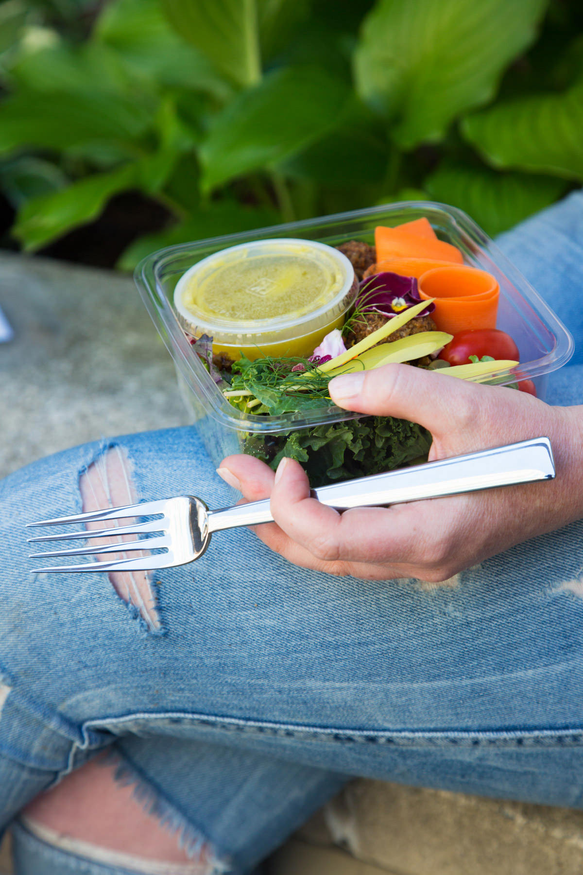 woman eating healthy salad to go